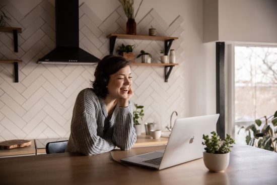 Lachende vrouw achter beeldscherm keuken